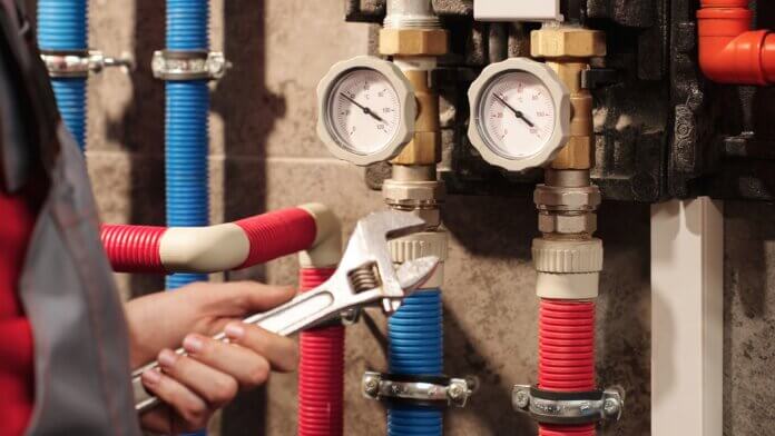 Sustainable Plumbing Upgrades Close Up Plumber With Wrench On Heating System In Utility